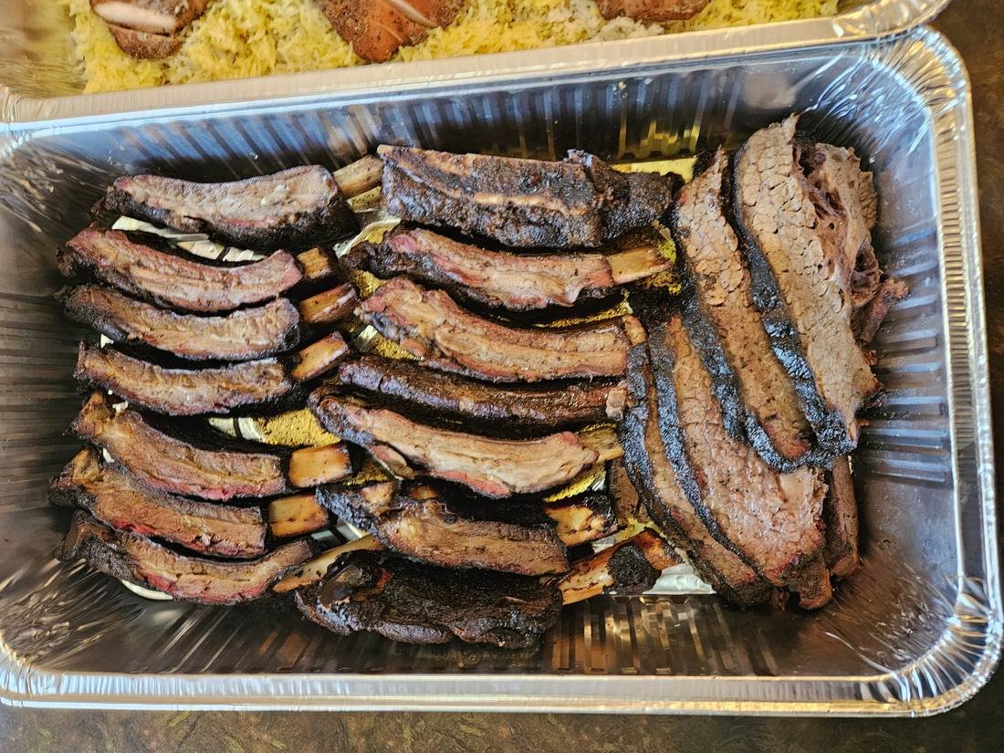 Catering tray of beef ribs and sliced brisket